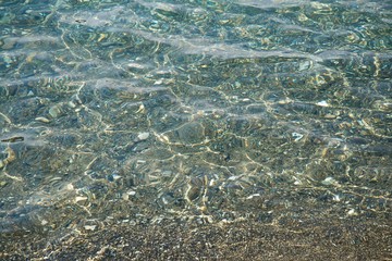 Texture of beach stones in shallow water