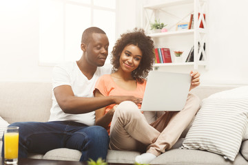 Young african-american couple working on laptop