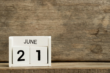 White block calendar present date 21 and month June on wood background