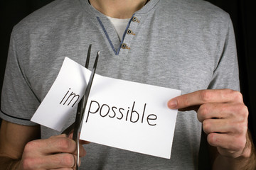 Impossible Is Possible Concept. card with the text impossible, cutting the word im so it written possible.