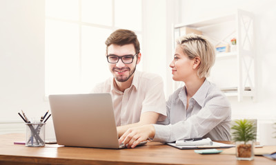 Couple of young colleagues working at modern office