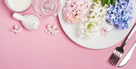 Spring festive Table setting with hyacinth flowers on a pink background