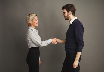 Couple of young colleagues shacking hands