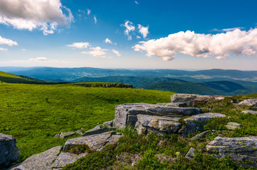 rocks on the edge of grassy meadow on hillside