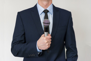 Man in business suit holding a microphone