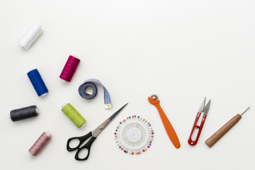 Tailor's work desk. Pattern of sewing accessories and tools on white background top view copyspace
