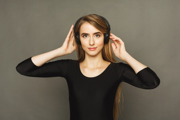 Woman listen to music in earphones, studio shot