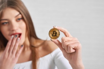 Focus on popular golden cryptocurrency bitcoin being futuristic virtual money hold by excited...