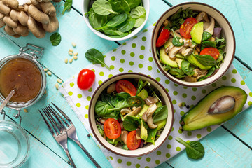 Healthy vegetarian lunch bowl. Avocado, mushrooms, cherry tomatoes, pine nuts, spinach and dressing...