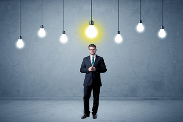 Obraz premium Businessman standing uninspired with bulbs above