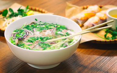 Pho Bo - traditional vietnamese noodel soup with beef in a bowl, closeup view. Film effect Filter.