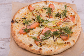 Pizza with the baked trout and onions of jalapeno, is served with greens