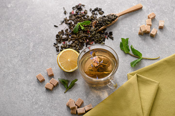 Composition with cup of aromatic tea on table
