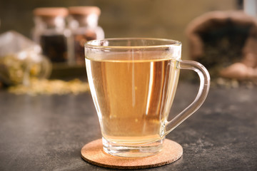 Glass cup of aromatic tea on table