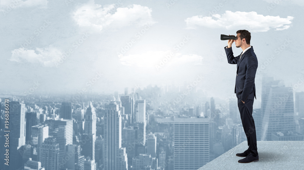 Wall mural man looking forward from the top of a skyscraper