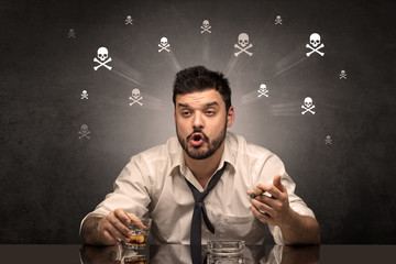Drunk man sitting at table with skulls concept