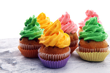 Tasty cupcakes on wooden background. Birthday cupcake in rainbow colors