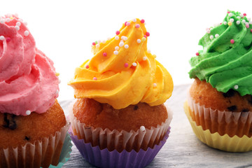 Tasty cupcakes on wooden background. Birthday cupcake in rainbow colors