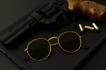 sunglasses and a gun on a black background