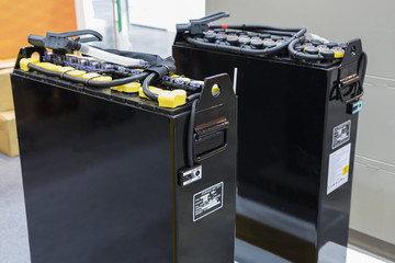 Industrial battery  is a device consisting of electro-chemical cells with external connections provided to power electrical for forklift/vehicle  / automotive  ; close up ; industrial background