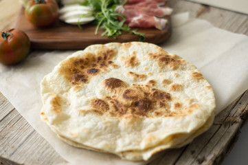 Homemade Italian flatbread called piadina with rocket salad, prosciutto and ricotta cheese.