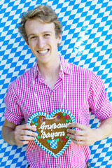 bavarian young man holding a heart-shaped gingerbread