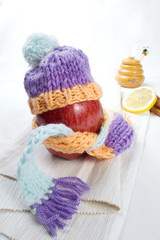 Concept of flu sick person with cap and scarf with healthy tea, fruit and vegetable