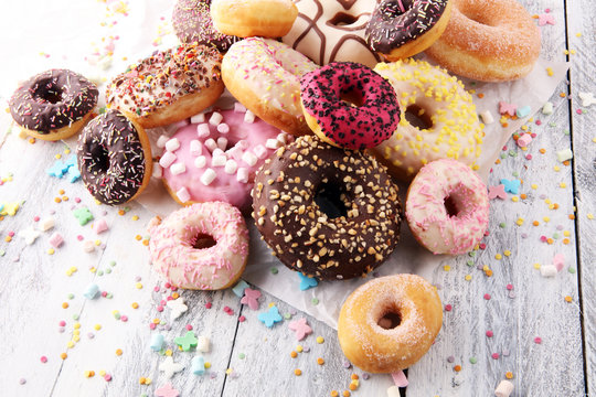 assorted donuts with chocolate frosted, pink glazed and sprinkles donuts.