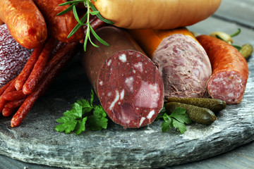 Food tray with delicious salami, ham,  fresh sausages, cucumber and herbs. Meat platter