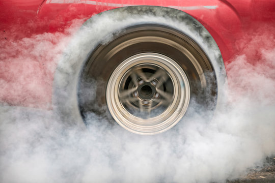 Drag racing car burns rubber off its tires in preparation for the race © toa555