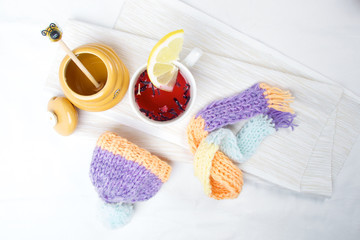 Concept of flu sick person with cap and scarf with healthy tea, fruit and vegetable