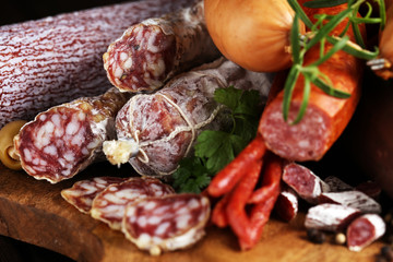 Food tray with delicious salami, ham,  fresh sausages, cucumber and herbs. Meat platter