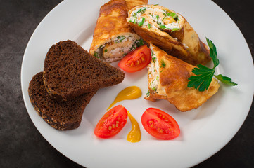 Homemade French omelette with cottage cheese, herbs and tomatoes. Old black rustic background. Top view