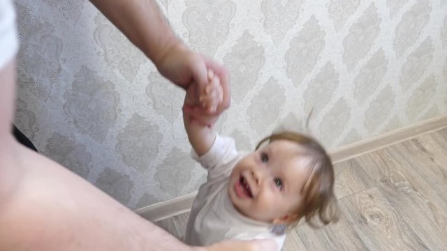 Small baby laughs playing with his father game room.