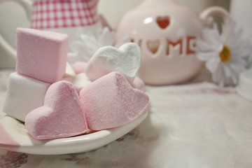 Obraz na płótnie Canvas Pink and White Marshmallow marshmallow in heart shape on the table . Pastel color dessert. Selective focus. Soft focus 