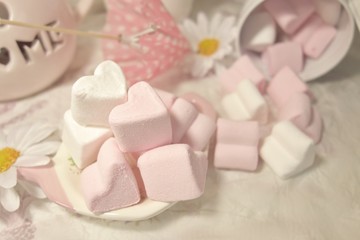 Fototapeta na wymiar Pink and White Marshmallow marshmallow in heart shape on the table . Pastel color dessert. Selective focus. Soft focus 