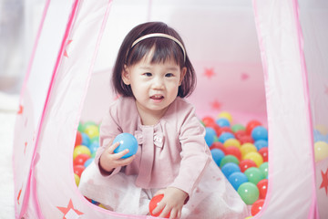 Fototapeta na wymiar baby girl play tent and ocean ball at home