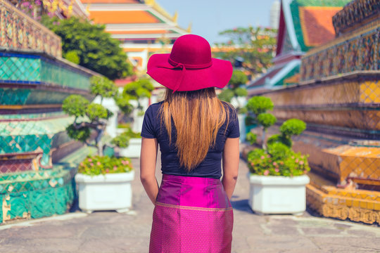 rear view of a Women tourist with traditional clothes visiting a temple in Thailand in day