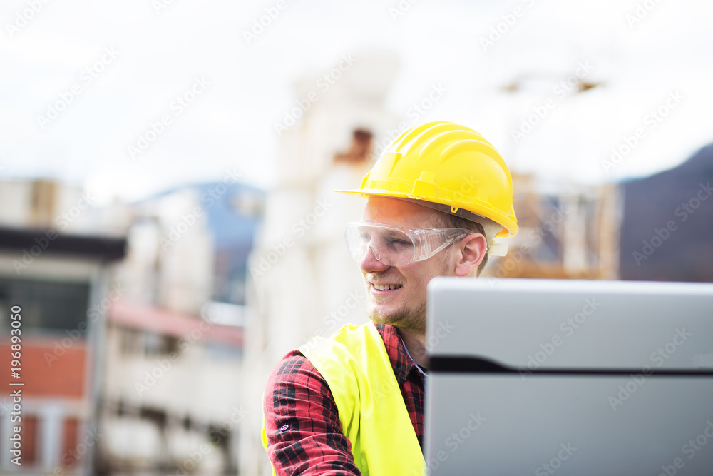 Wall mural Construction worker with laptop