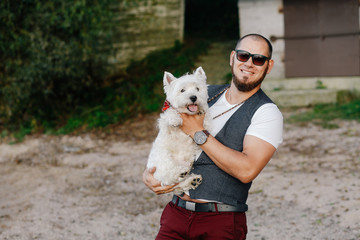 brutal man hugs his little white dog