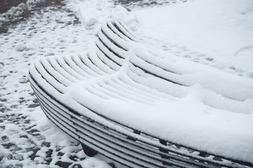 closeup of metallic bench covered by snow