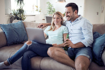 Obraz na płótnie Canvas Couple on sofa using a laptop
