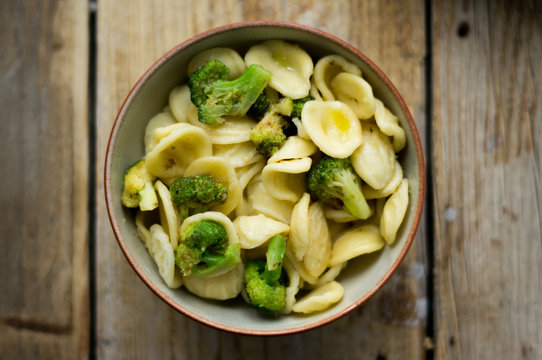 Homemade pasta orecchiette with broccoli, Italian suasage and parmesan on the wooden rustic table