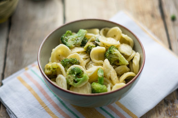 Homemade pasta orecchiette with broccoli, Italian suasage and parmesan on the wooden rustic table