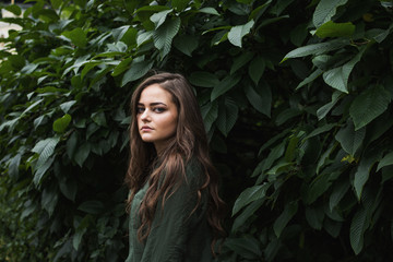 Beauty Romantic Girl Outdoor. Beautiful Teenage Model Dressed in Fashionable Green Dress Posing Outdoors in park. Toned in warm colors