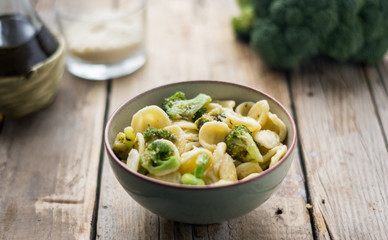 Homemade pasta orecchiette with broccoli, Italian suasage and parmesan on the wooden rustic table