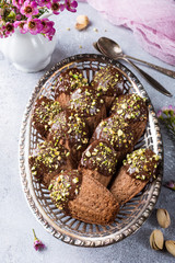 Homemade chocolate cookies Madeleine with chopped pistachio nuts in metal basket. Holidays and party food concept