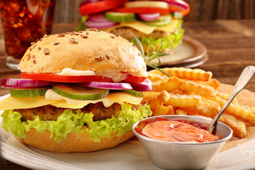 Fresh tasty burger with fries and beer on wooden table