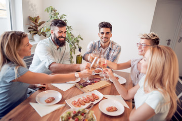 Smiling friends toasting with glasses of wine