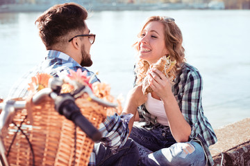 Young couple eating sandwich and having a great time
